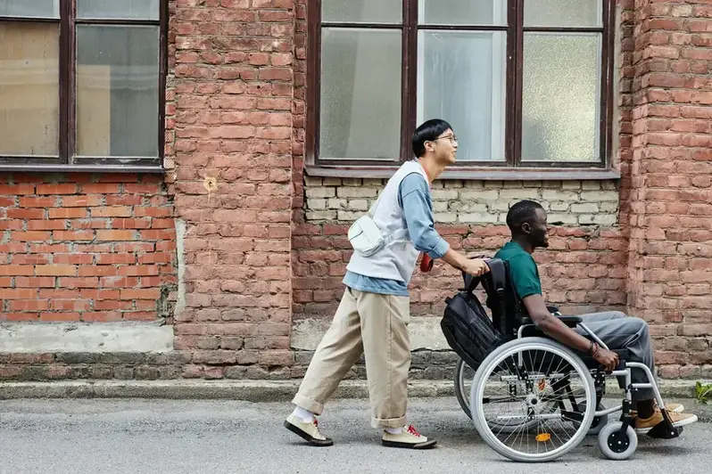 Disabled man in wheelchair being accompanied by male carer