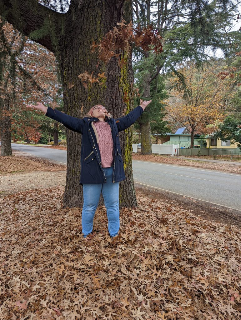 Woman standing with confident empowered posture under a tree