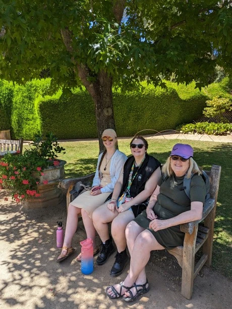 Founder sitting on bench with friends and family