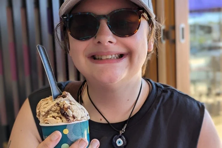 Girl holding ice cream smiling while looking at the camera