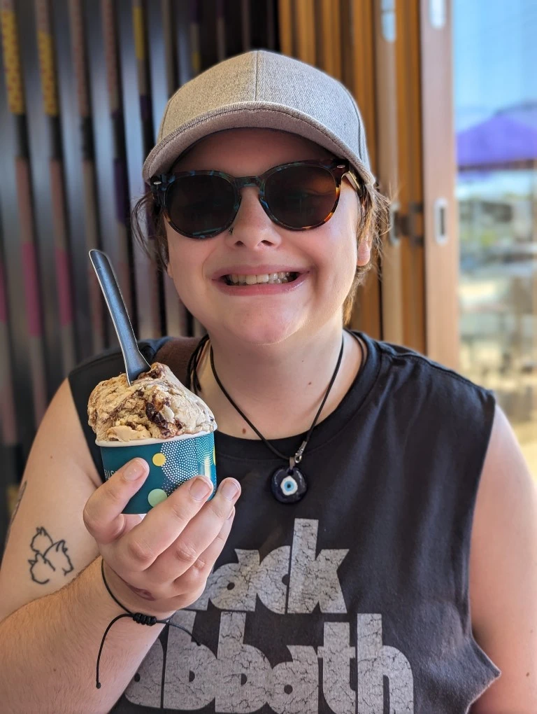 Girl holding ice cream smiling while looking at the camera