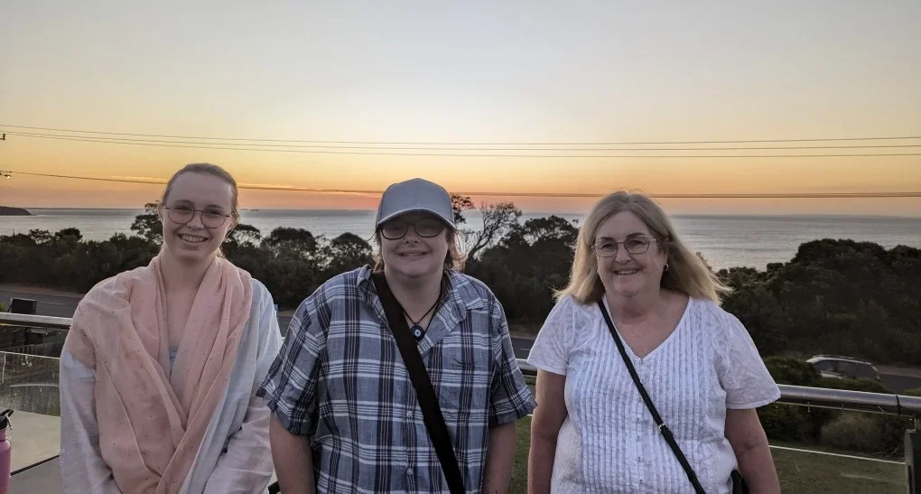 Founder with friends and family standing on a balcony overlooking a scenic ocean view